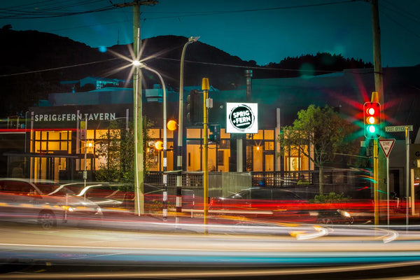Night scene of Sprig + Fern Berhampore with traffic and lights.
