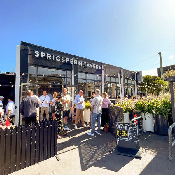 People outside the Sprig + Fern Berhampore tavern on a sunny day.