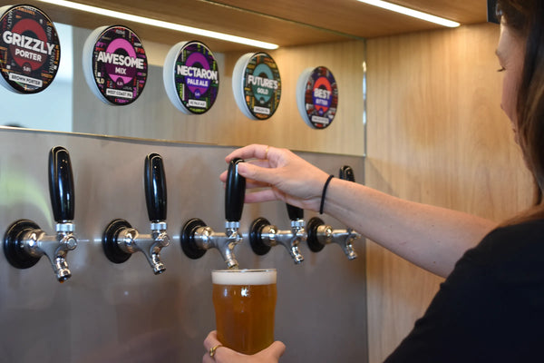 Person pouring Sprig + Fern beer from a tap in a Proper Pint Glass behind the bar of Sprig + Fern Marsden.