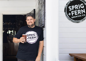 The owner of Sprig + Fern Milton Street, Karl Russ, holding a pint of beer.