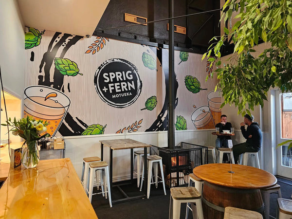The interior of the Sprig + Fern Motueka with two patrons enjoying a beer.
