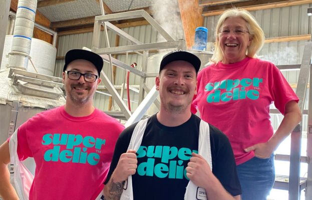 Three employees of Sprig and Fern Brewing Co wearing Superdelic tee shirts