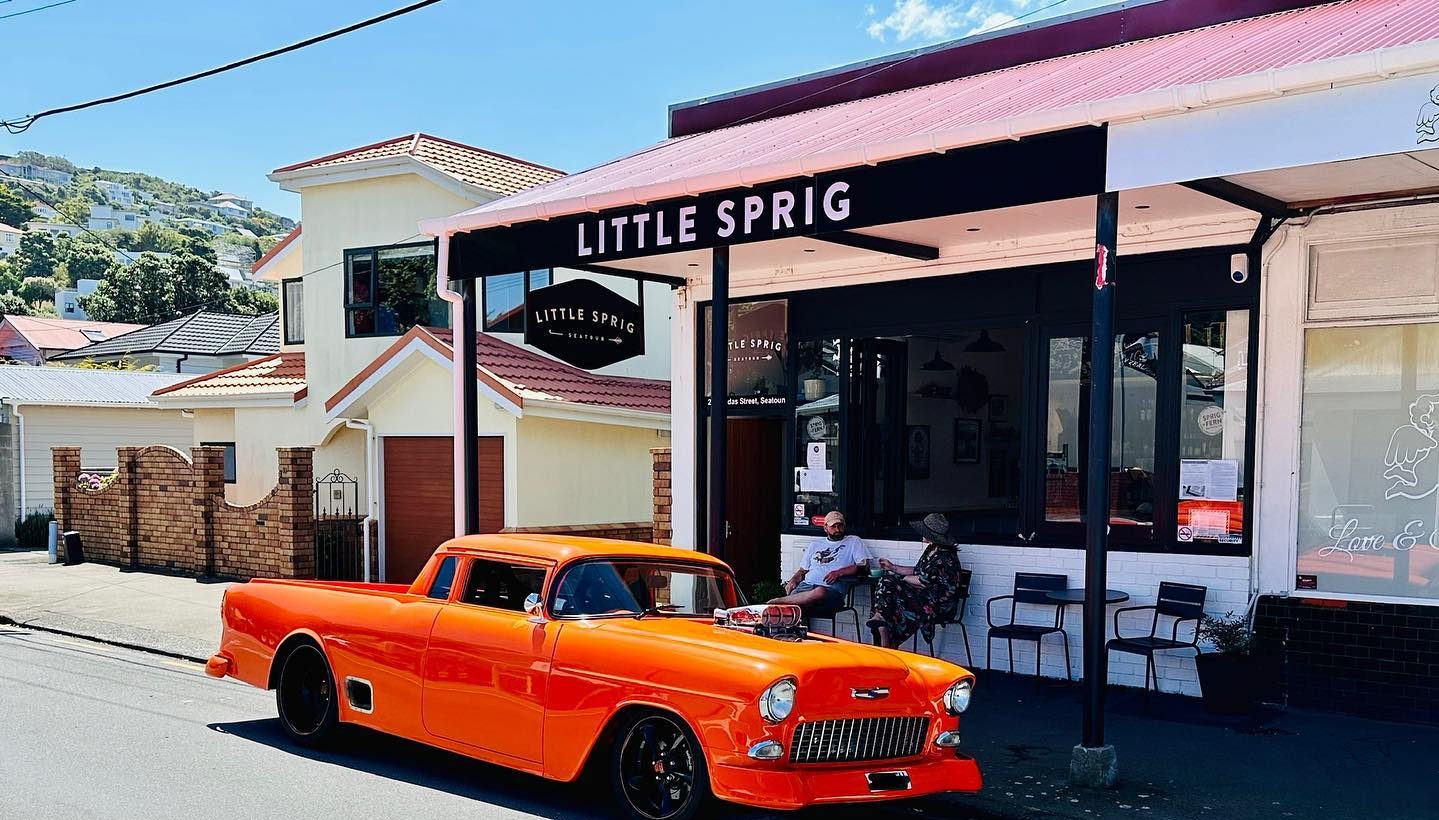 An orange car parked outside Little Sprig Seatoun