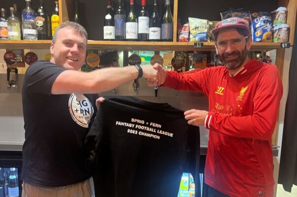 John from Sprig and Fern Berhampore shaking hands with regular Nick, who won the Sprig and Fern Fantasy Football league in 2023