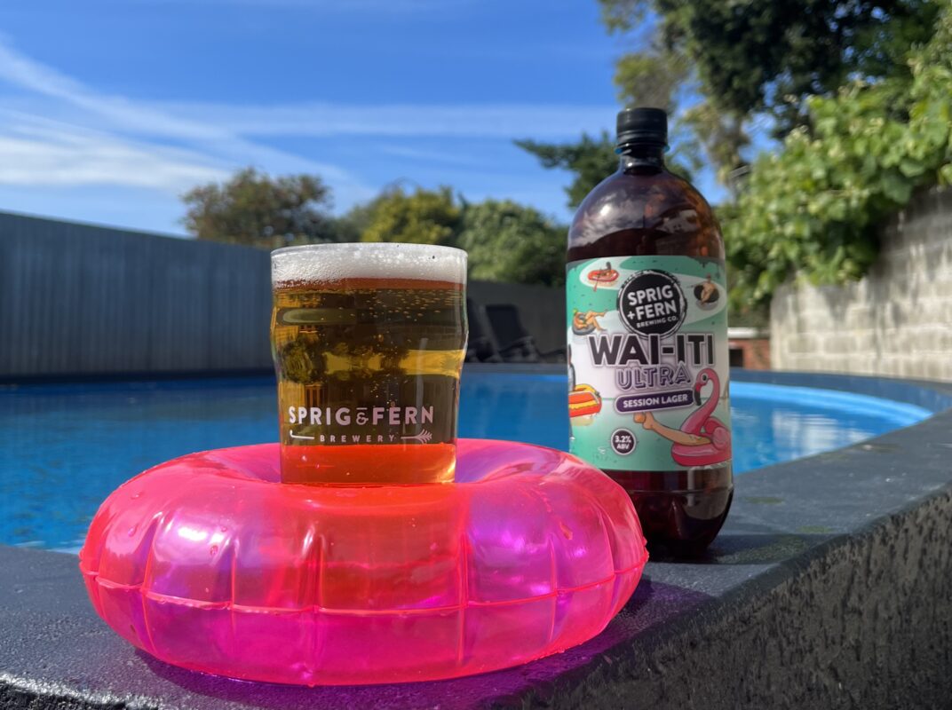 A rigger and a pint of Wai-iti Ultra Session Lager next to a swimming pool