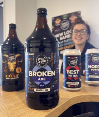 Kathryn Banner in the Sprig and Fern Cellar Door with a bottle of The G.O.A.T Doppelbock, Broken Axe Scotch Ale, a can of Best Bitter and Norty Porter - all winners of medals at the Australian International Beer Awards